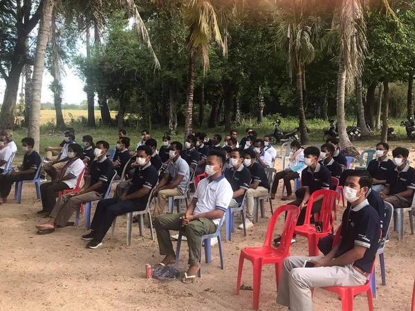 A group of people sitting on chairs at an outdoor event