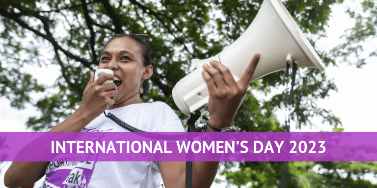 A women speaking into a megaphone at an International Women's Day rally
