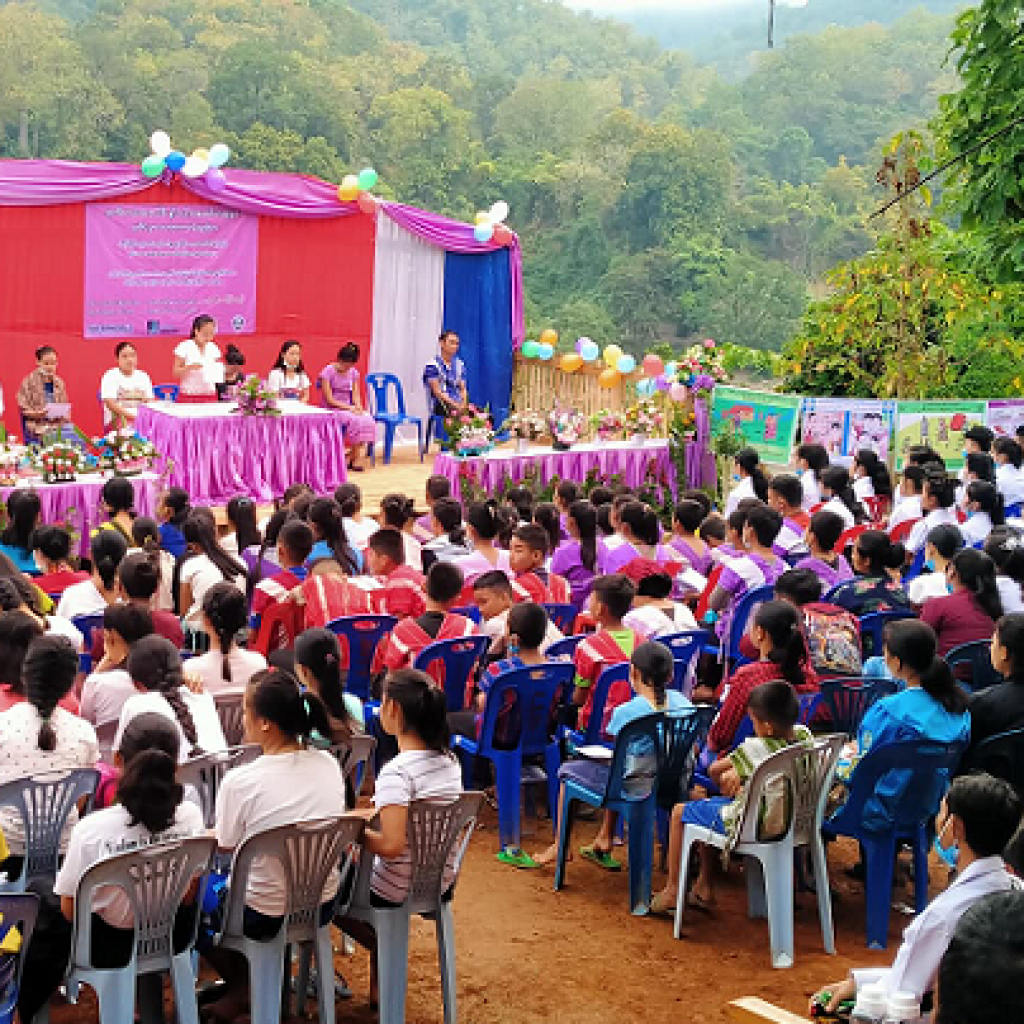 A group of people sitting on chairs at an outdoor event