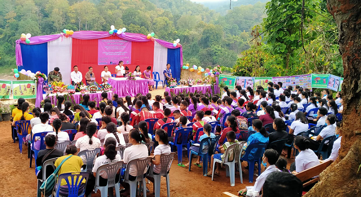 A group of people sitting on chairs at an outdoor event