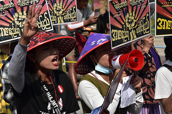 Women speak into a megaphone at a rally in Myanmar