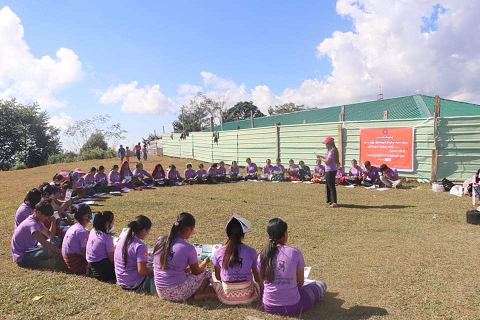 A group of people sit in a circle and read information booklets