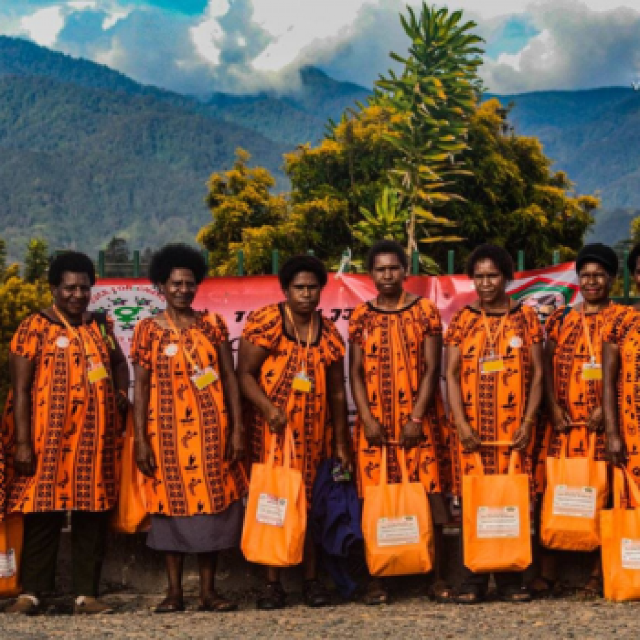A goup of people stand together in patterned orange print clothing