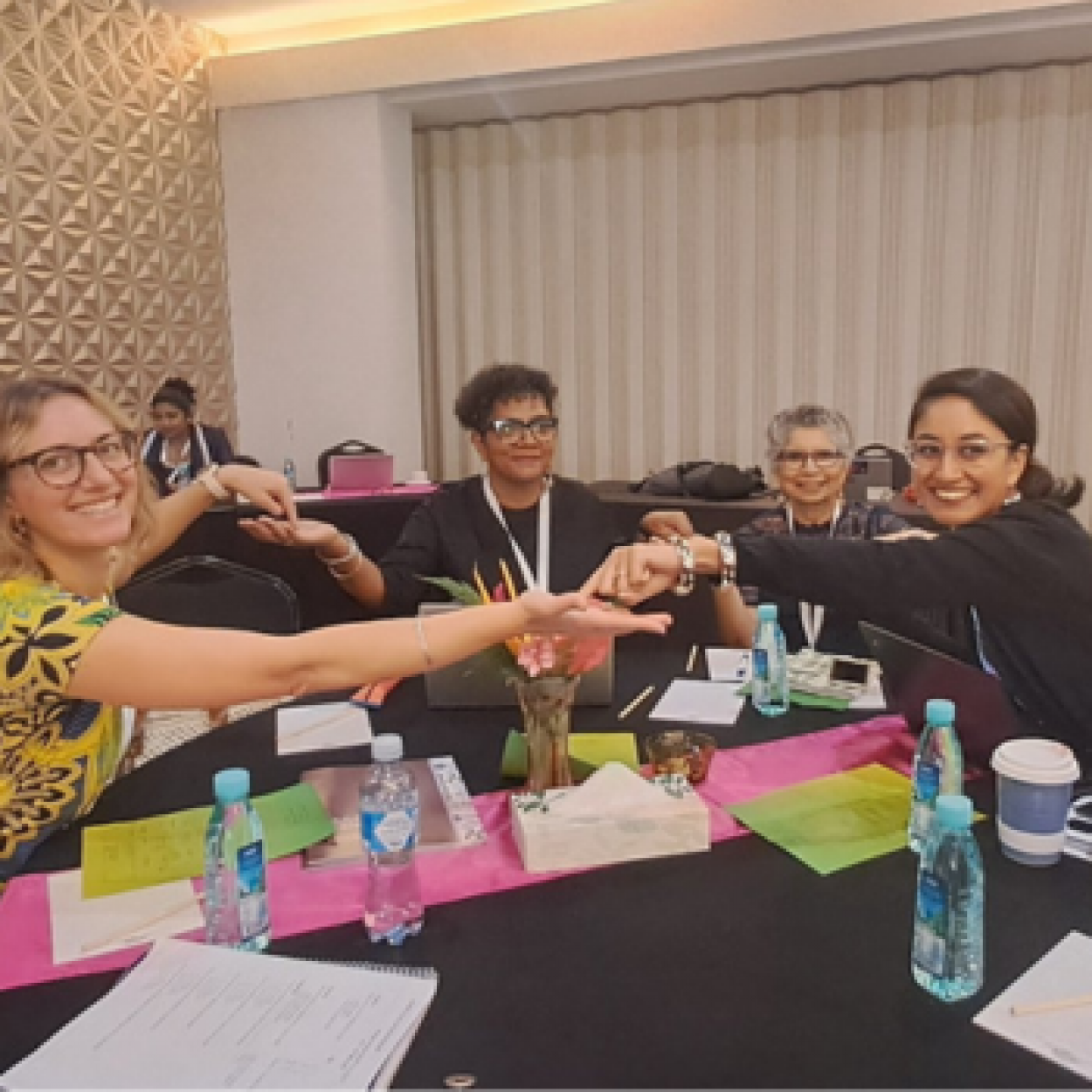 People link hands over a workshop table in Fiji