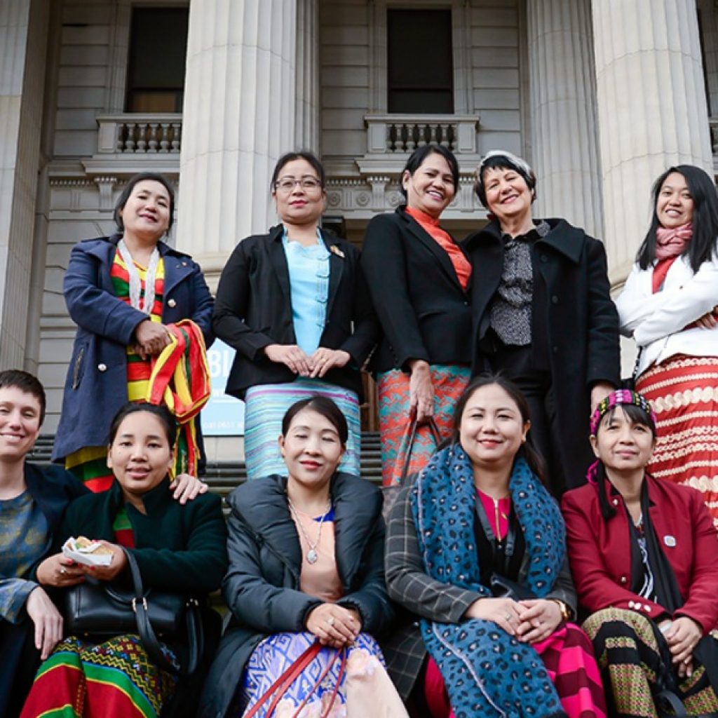 Image of women Myanmar MPs, IWDA staff and Emilys List founder standing outside Victoria's parliament building