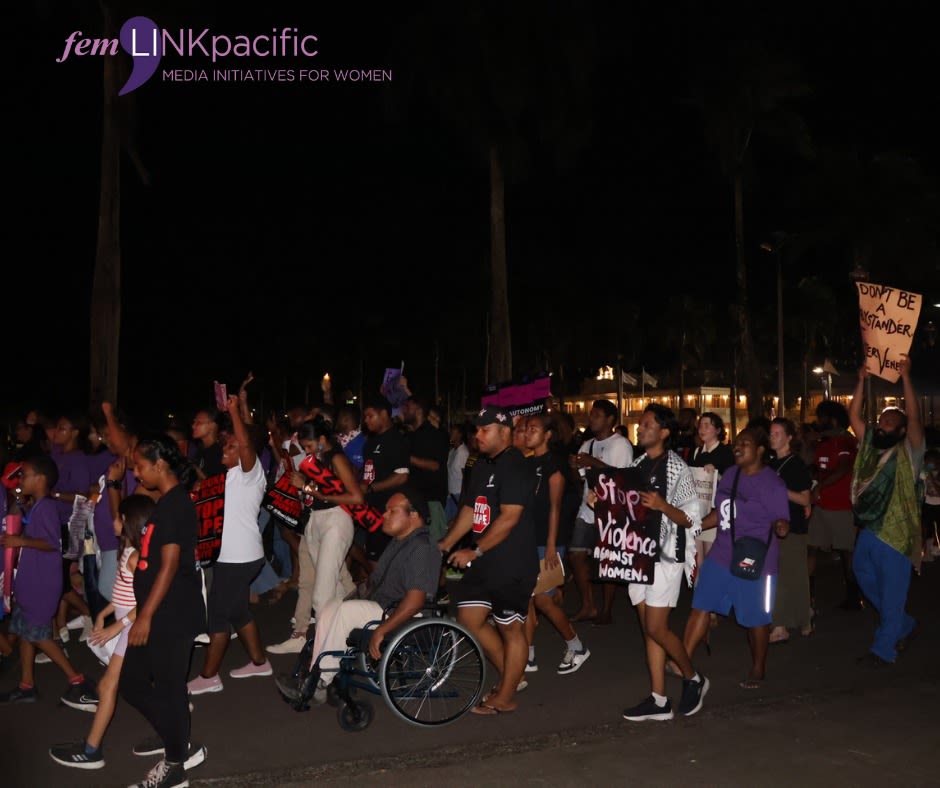 A large group of people marching through the streets of Suva as they talk part in the 'Reclaim the Nigh' rally. At the centre of the shot is a person in a wheelchair.