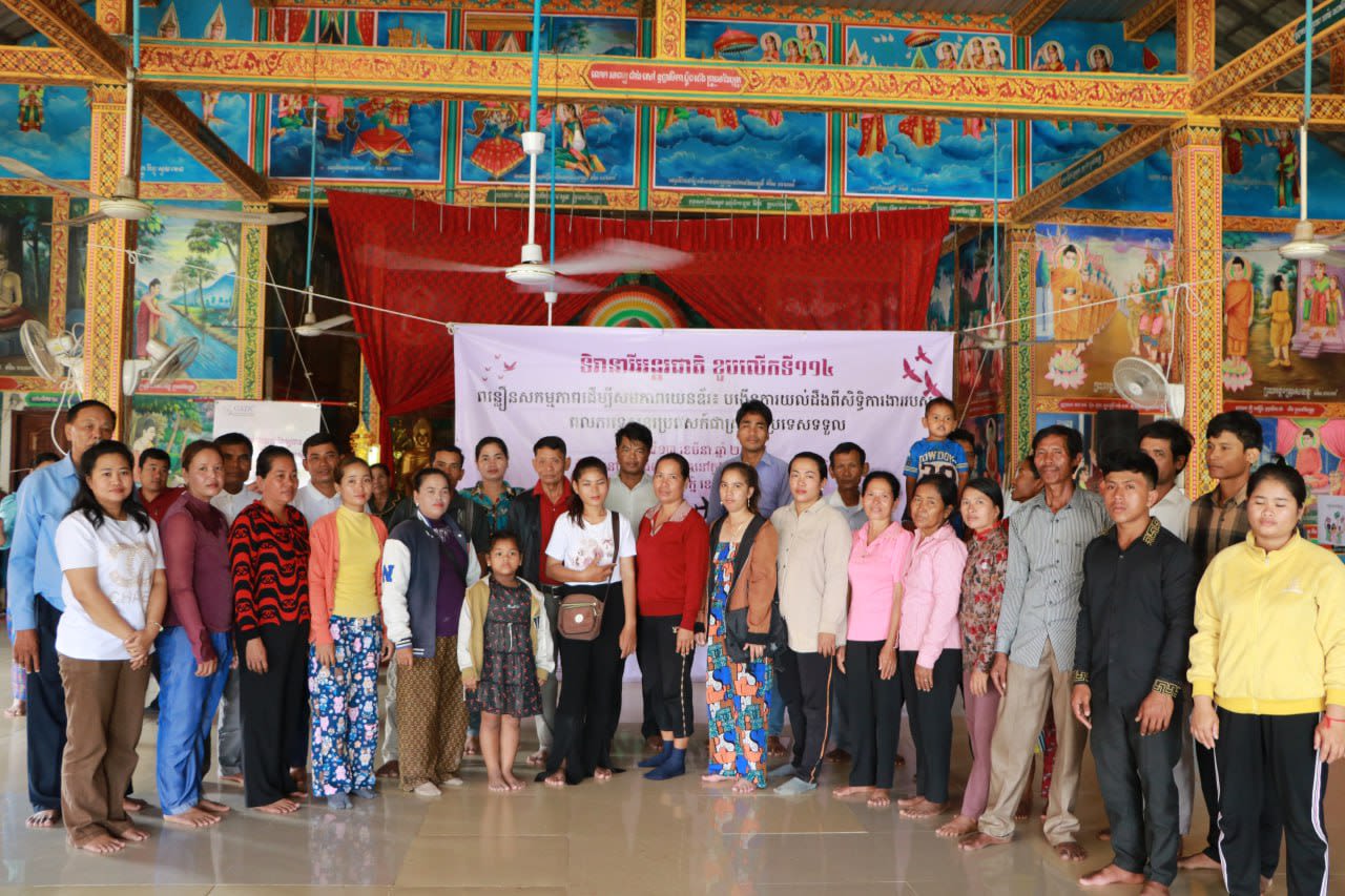 A large group of people are posing together for a photo at GADC's event on the rights of migrant women workers.