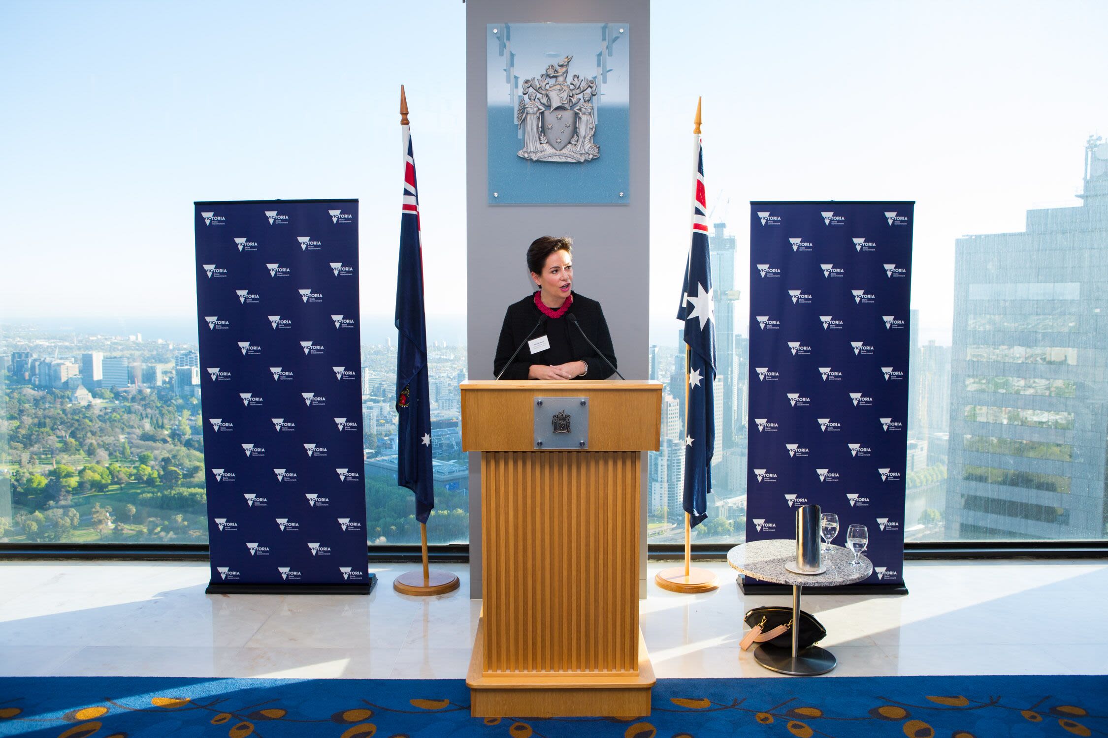 Bettina is standing behind a podium as she addresses the room.